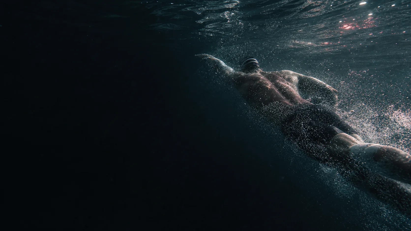 Open-water swimmer moving through dark water